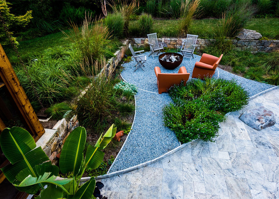 Stone Fire Pit Circle With Plantings And Colored Furniture